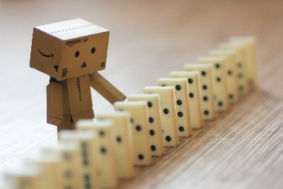 A cardboard robot playing with dominos